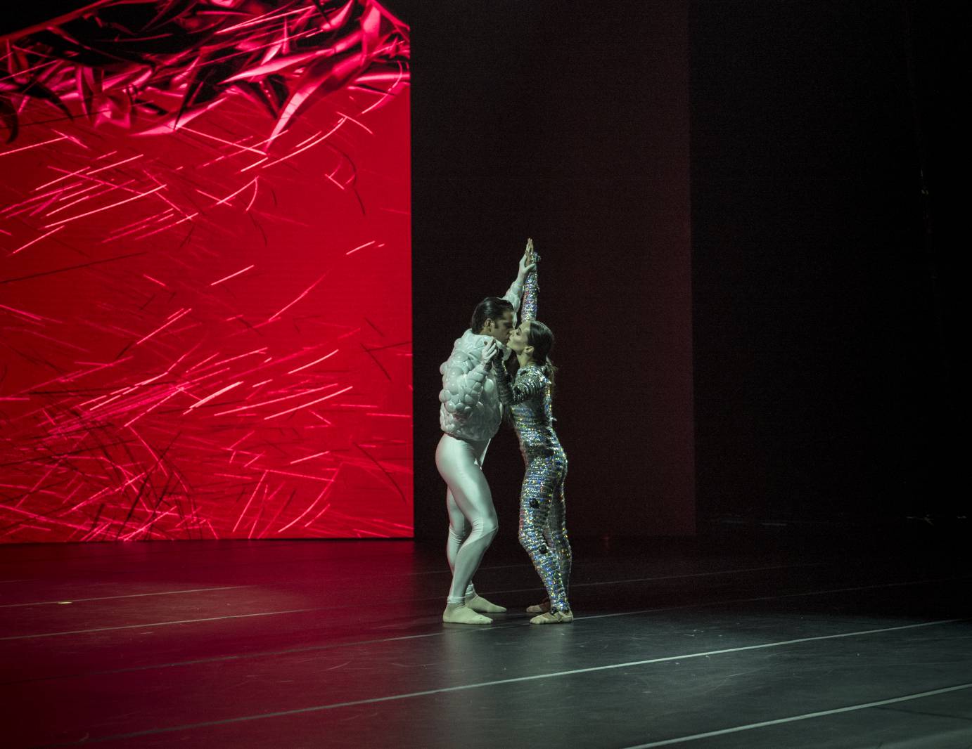 Two dancers against a red projection
